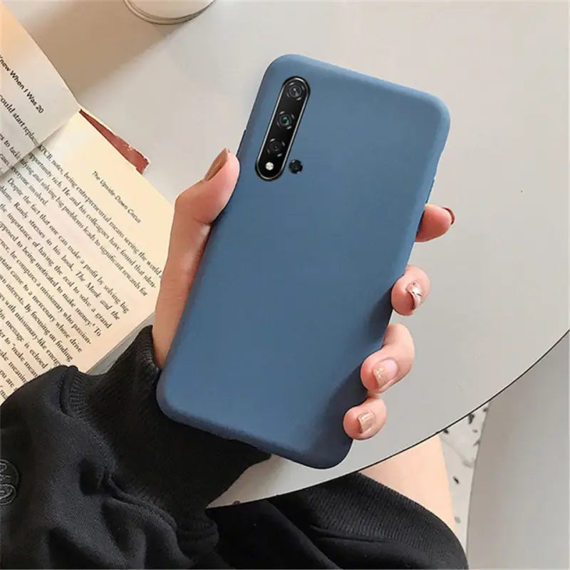 a woman holding a blue phone case