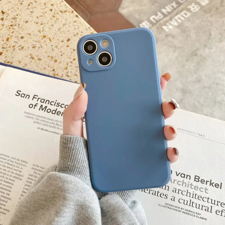 a woman holding a blue iphone case