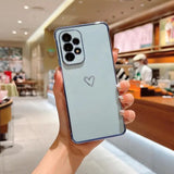 a woman holding up a phone case with a heart drawn on it