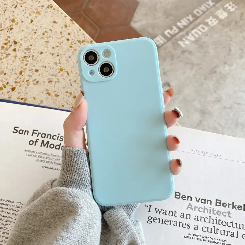 a woman holding a blue iphone case