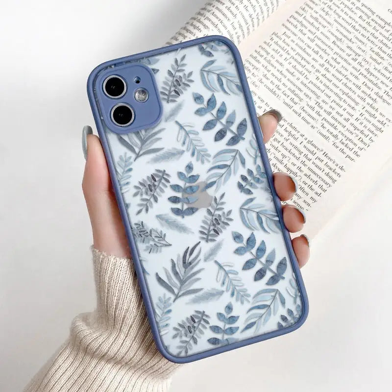 a woman holding a blue phone case with a floral pattern
