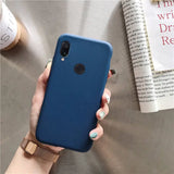 a woman holding a blue phone case