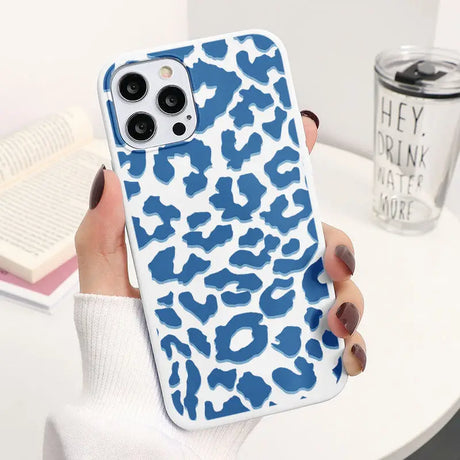 a woman holding a blue and white phone case