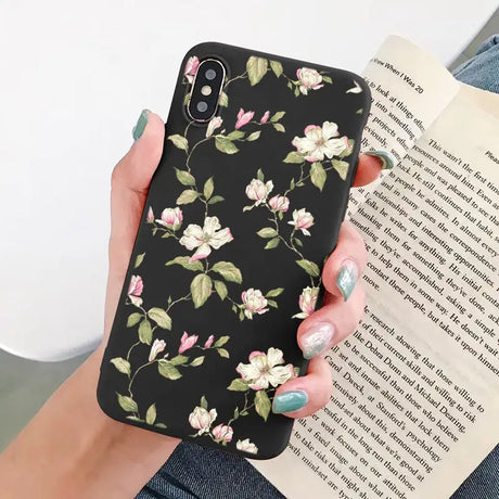 a woman holding a book and a phone case