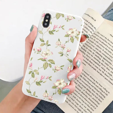 a woman holding a book and a phone case