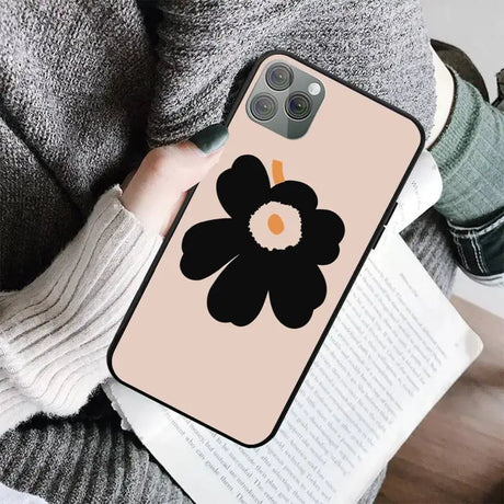 a woman holding a book and a phone case