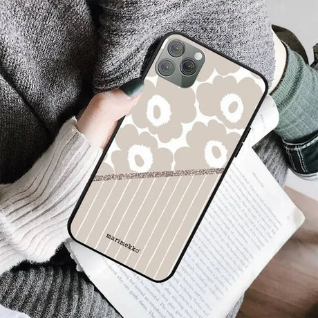 a woman holding a book and a phone case