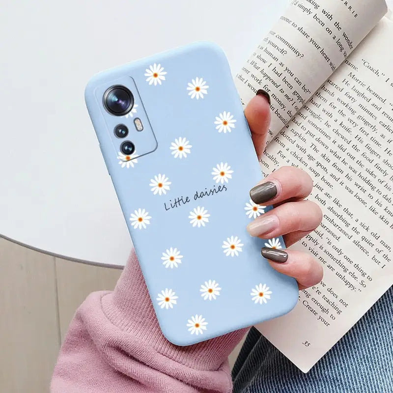 someone holding a phone case with daisies on it