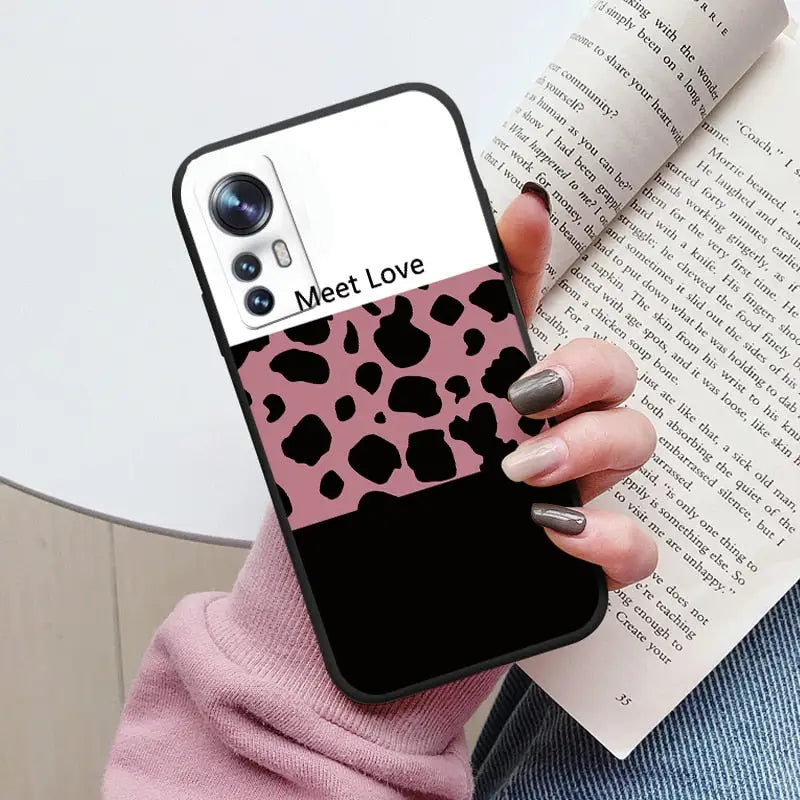 a woman holding a book and a phone case