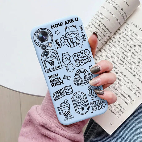 a woman holding a book and a phone case