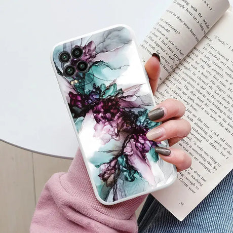 a woman holding a book and a phone case