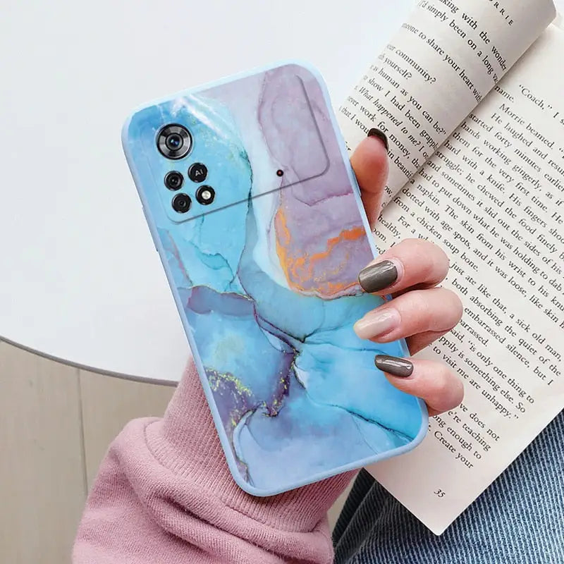 a woman holding a book and holding a phone case