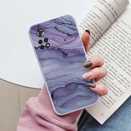 a woman holding a book and a phone case