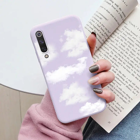 a woman holding a book and a phone case