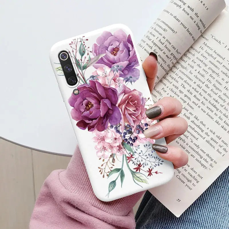 a woman holding a book and a phone case