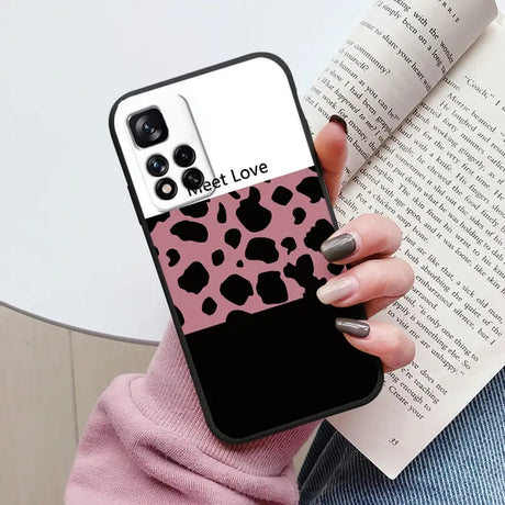 a woman holding a book and a phone case