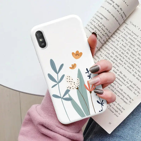 a woman holding a book and a phone case