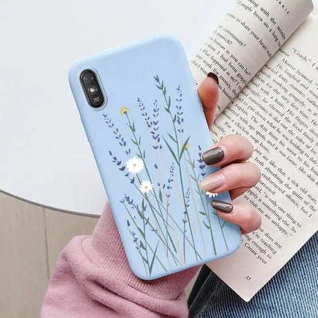 a woman holding a book and a phone case