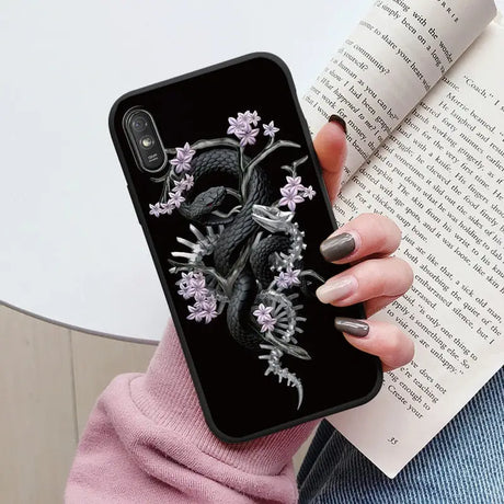 a woman holding a book and a phone case