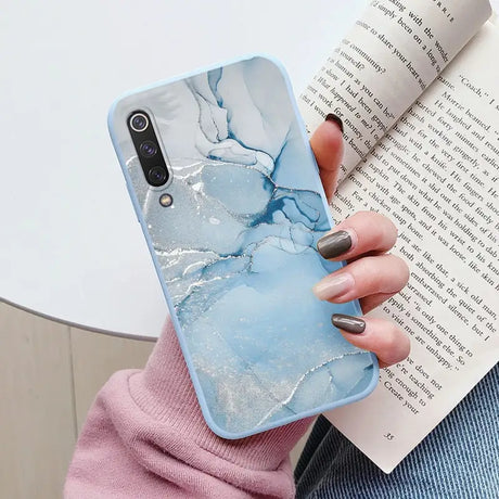 a woman holding a book and a phone case