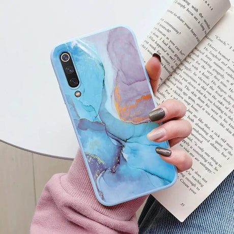 a woman holding a book and a phone case