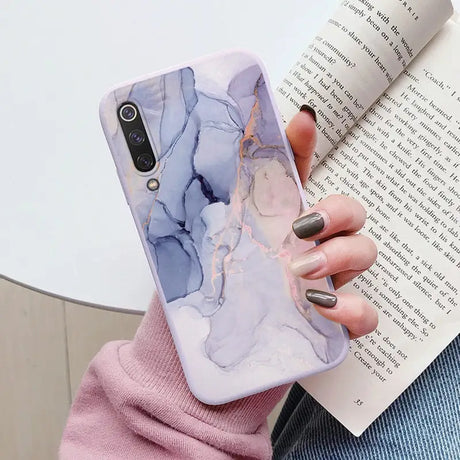 a woman holding a book and a phone case