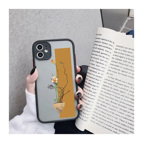 a woman holding a book and a phone case