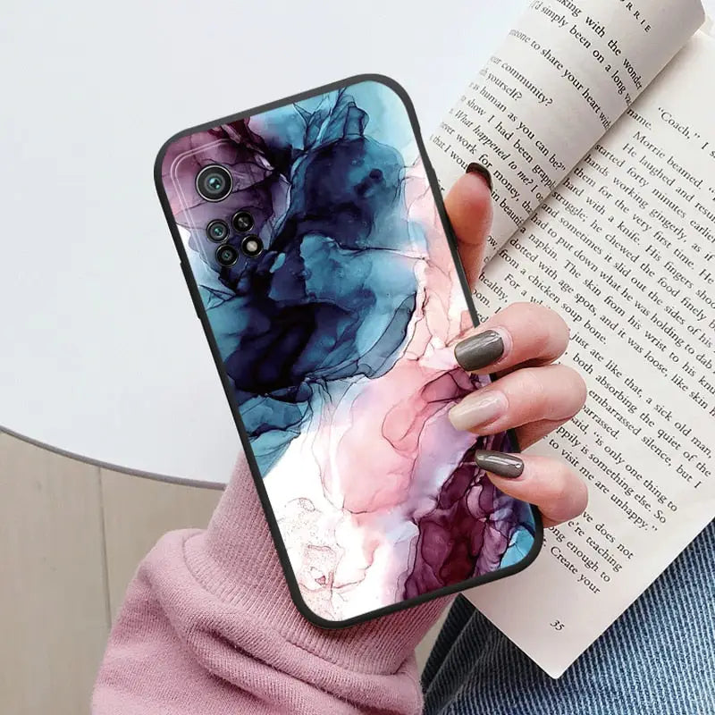 a woman holding a book and holding a phone case