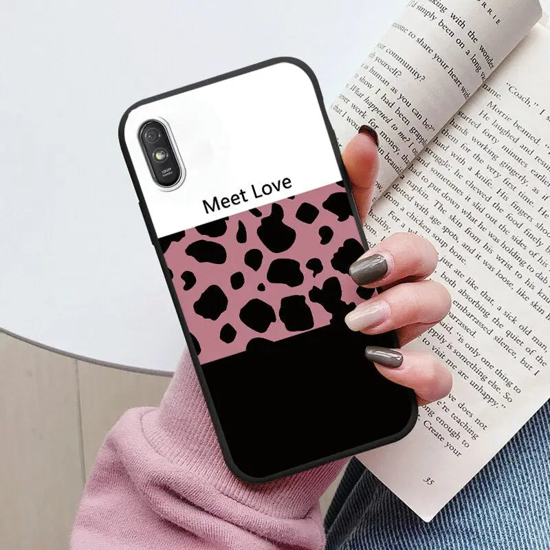a woman holding a book and a pink phone case