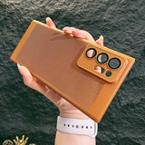 a hand holding a brown iphone case