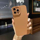 a woman holding up a brown iphone case