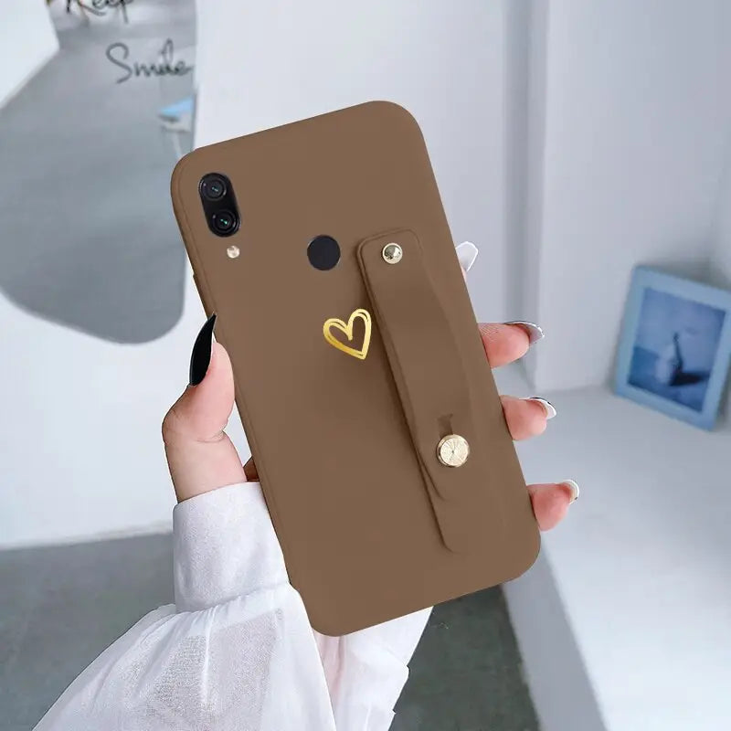 a woman holding a brown phone case with a heart shaped handle