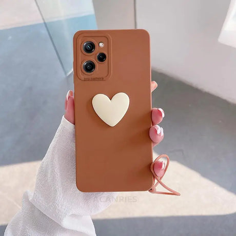 a woman holding a brown phone case with a heart on it