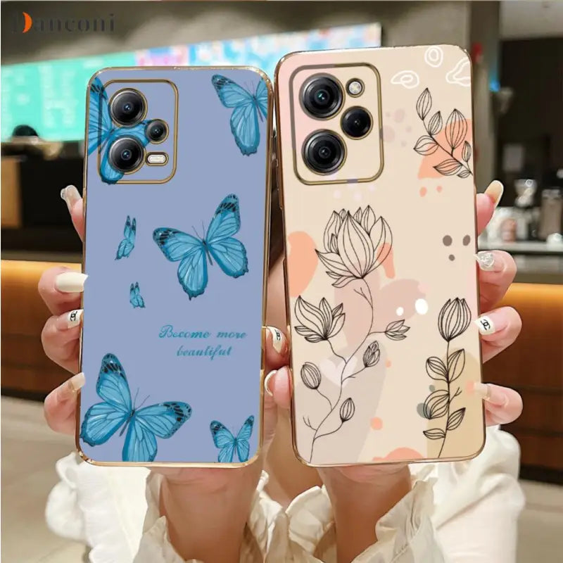 a woman holding up two cases with butterflies on them