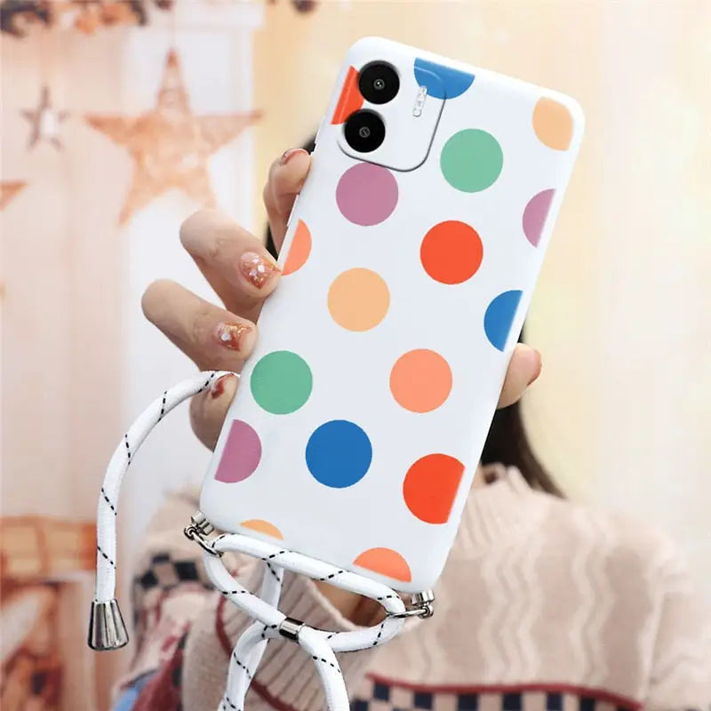 a woman holding a cell case with colorful polka dots