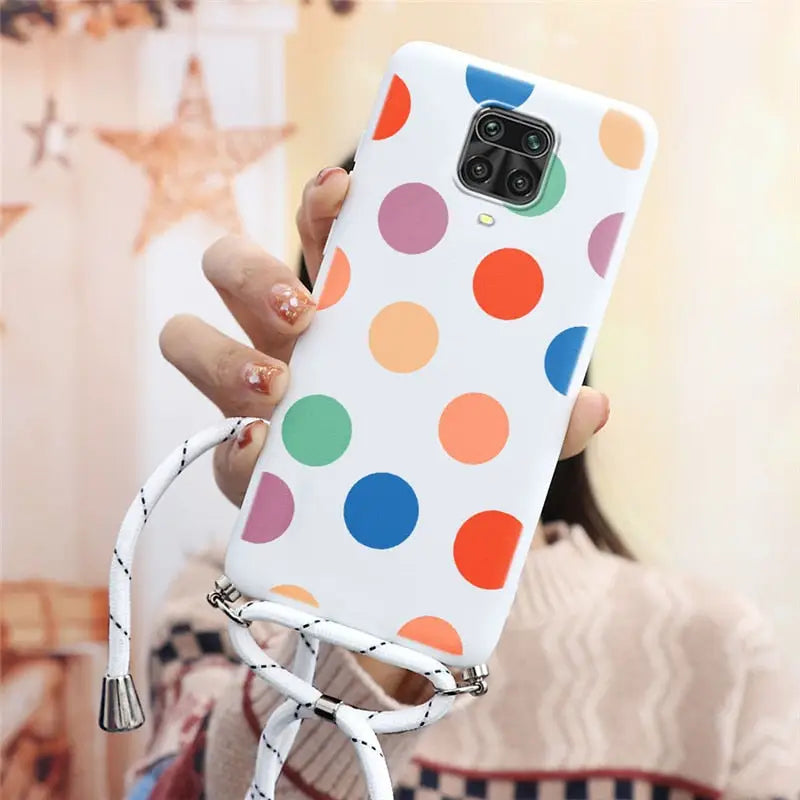 a woman holding a cell case with colorful polka dots