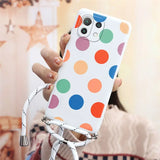 a woman holding a cell phone case with colorful polka dots