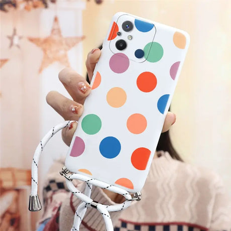 a woman holding a cell phone case with colorful polka dots