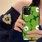 a woman holding a cell phone with a green and white pattern