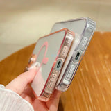 a woman holding a phone with a pink and silver case
