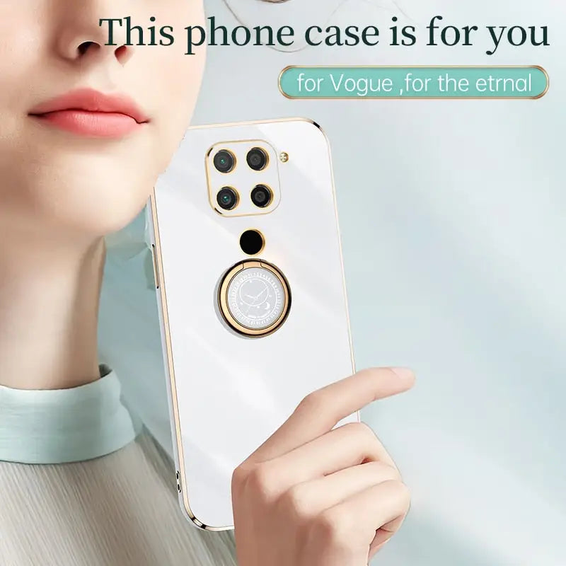 a woman holding a cell phone with a ring on it