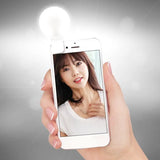 a woman holding a cell phone with a light shining on it