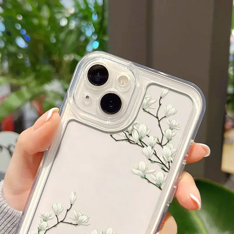 a woman holding a clear phone case with white flowers on it