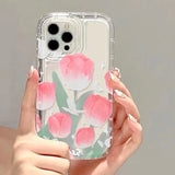 a woman holding a clear phone case with pink flowers