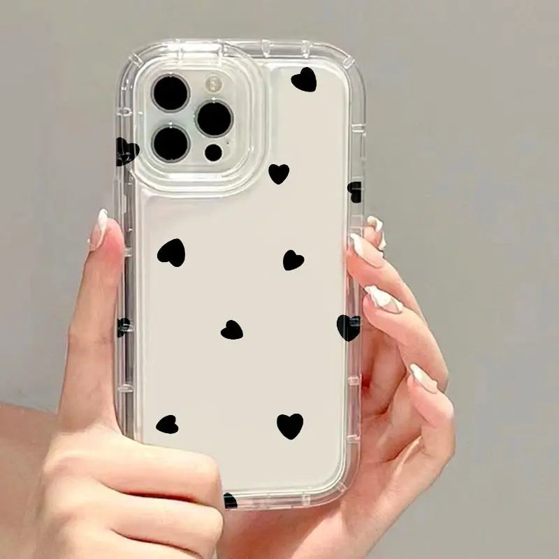 a woman holding a phone case with black hearts on it