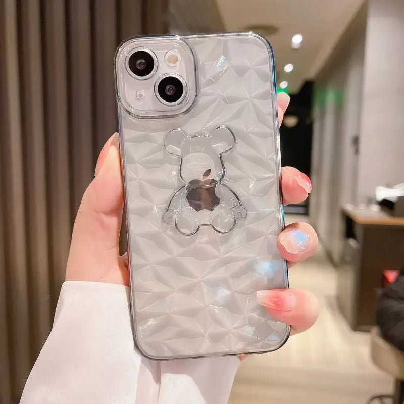 a woman holding a clear phone case with a diamond pattern