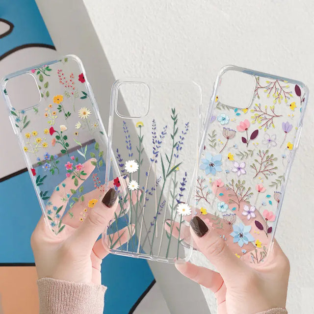 a woman holding a clear phone case with flowers on it