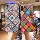 a woman holding up a phone case with colorful patterns