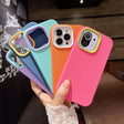 a woman holding up four colorful iphone cases