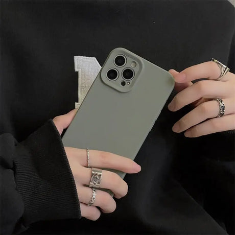 a woman holding a gray iphone case